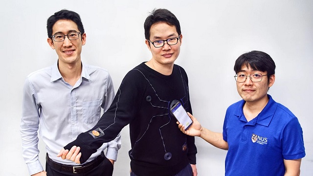 Inteligentné športové oblečenie na posudzovanie výkonu nositeľa, ktoré predstavuje vedecký tím (odborný asistent John Ho (vľavo), Dr. Lin Rongzhou (v strede) a Dr. Kim Han-Joon (vpravo)).