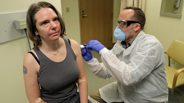 Jennifer Haller, dobrovoľníčka z klinického testovania, dostane vôbec prvú injekciu experimentálnej vakcíny proti koronavírusu. Zdroj: Ted S. Warren / AP Photos.