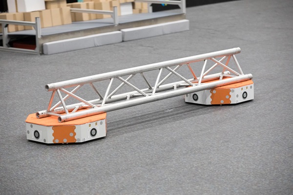Pomocou technológie roja môžu dva robotické transportéry LoadRunner spoločne prenášať nosník. 
