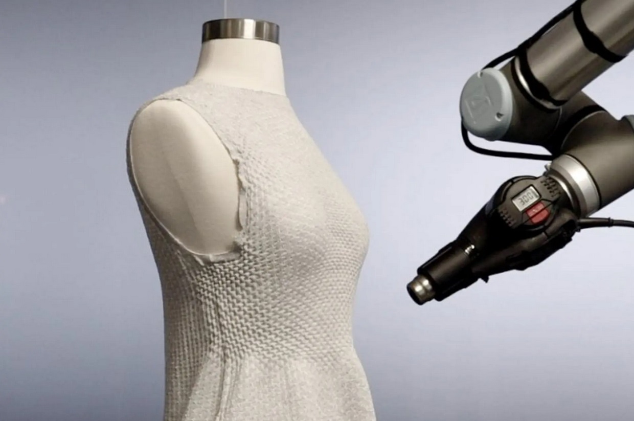 Aktívna priadza v 4D pletených šatách je upravená robotom s teplovzdušnou pištoľou.