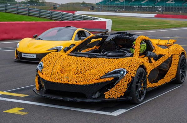 Lego model hyperauta McLaren P1 na pretekárskej dráhe s reálnym vozidlom.