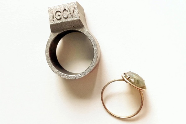 Prototyp inteligentného RFID prsteňa (hore) spolu s bežným prsteňom na porovnanie mierky.
