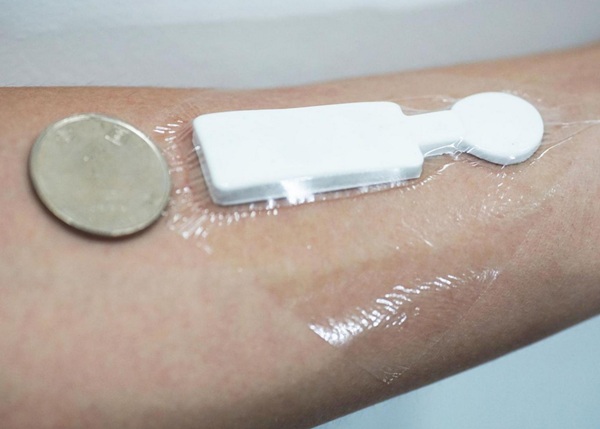 Schopnosť zariadenia monitorovať teplotu a vlhkosť (na obrázku s americkou štvrťdolárovou mincou pre mierku) sa testovala nielen na tvárach a čelách dobrovoľníkov, ale aj na ich rukách a končekoch prstov.