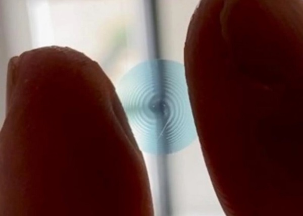 Vzorová špirálová kontaktná šošovka držaná medzi prstami výskumníka.