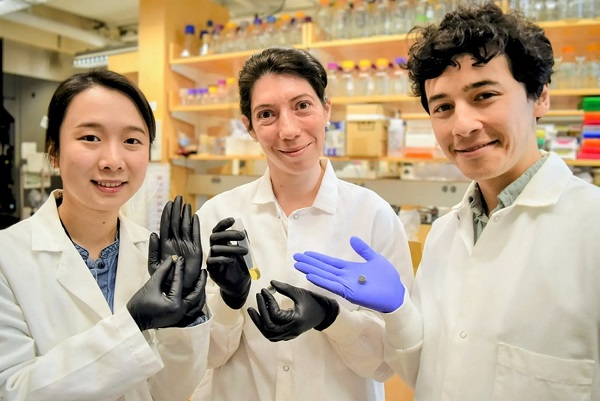 Zľava členovia tímu Qijun Liu z Bostonskej univerzity, Maria Eugenia Inda z MIT a Miguel Jimenez z MIT pózujú s tabletkou.