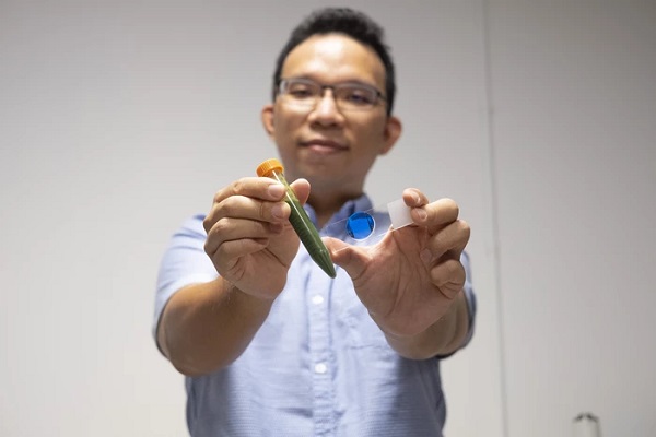 Autor štúdie profesor Chen Yu-Cheng s trubicou plnou rias a so sklíčkom s poľom mikrokvapiek.