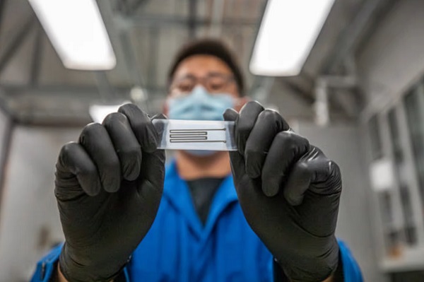 Výskumník Junpyo Kwon drží vzorku biologicky rozložiteľného elektronického obvodu.