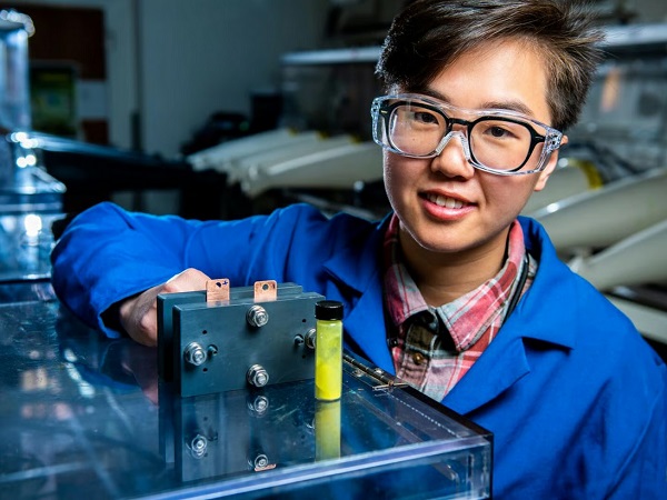 Výskumník prietokovej batérie Ruozhu Feng pózuje s prísadami pre dlhotrvajúcu energetickú batériu.