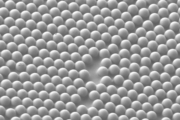Mikroskopický obraz drobných guľôčok, ktoré tvoria povrch nového materiálu mikroškálového konkávneho rozhrania.