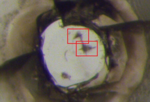 Snímka jednej z diamantových kovadliniek pod optickým mikroskopom. Jedna zo vzoriek super tvrdého polymorfu C3N4 vtlačila povrch kovadlinky.