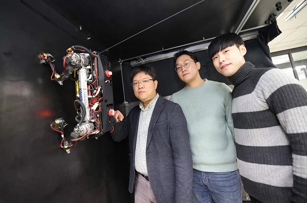 Zľava - profesor Hae-Won Park, doktorand Yong Um a doktorand Seungwoo Hong pózujú s robotom MARVEL.