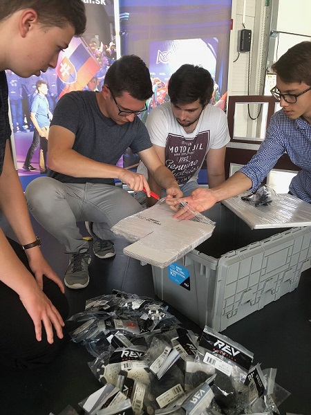 Tím študentov z FIRST Globla Slovakia rozbaľuje robotickú stavebnicu.