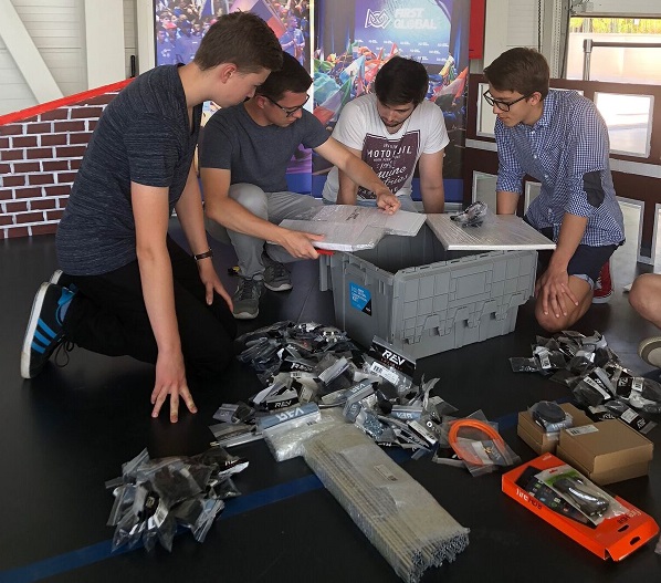Tím študentov z FIRST Globla Slovakia rozbaľuje robotickú stavebnicu.