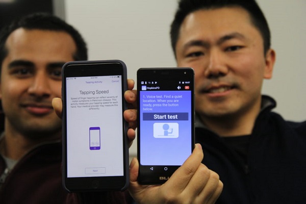 Študenti informatiky na univerzite Johnsa Hopkinsa, Srihari Mohan (vľavo) a Andong Zahn, zobrazujú iOS a Android verzie aplikácie, na ktorých pomáhali pri vývoji.
