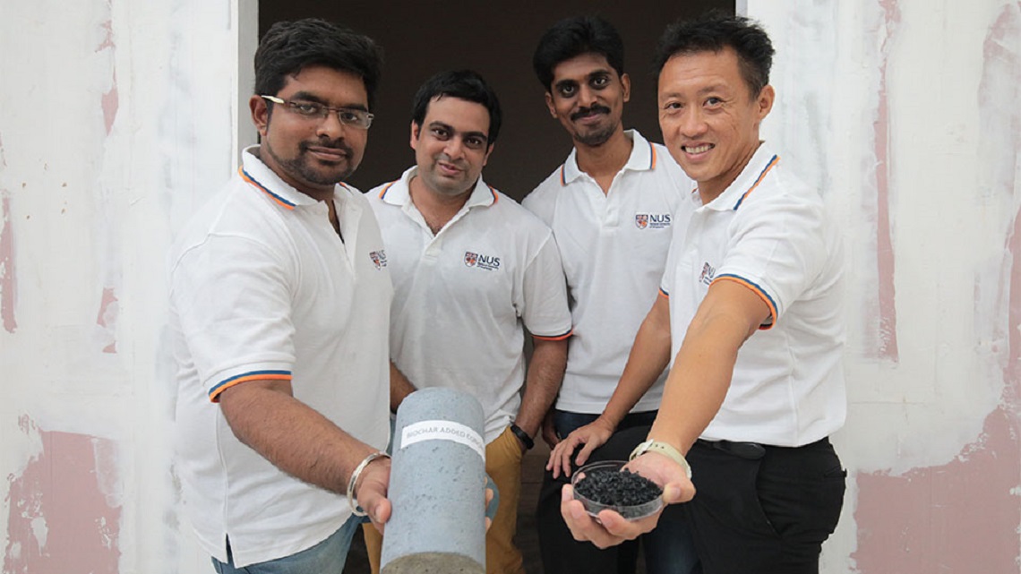 Výskumníci z Národnej univerzity v Singapure prezentujú na ľavej strane vylepšený kus betónu a na pravej strane je vzorka biocharu z dreveného odpadu, ktorý sa použil na výrobu betónu.