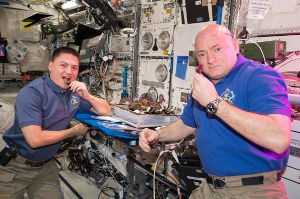 Astronauti Scott Kelly a Kjell Lindgren ochutnávajú šalát pestovaný na palube ISS v auguste 2014.